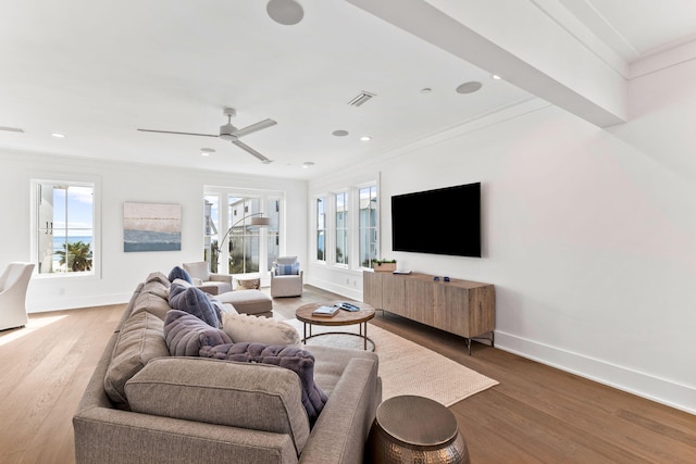 living room featuring ceiling fan, hardwood / wood-style flooring, and crown molding