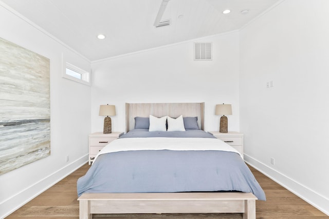 bedroom with ornamental molding, vaulted ceiling, and hardwood / wood-style flooring