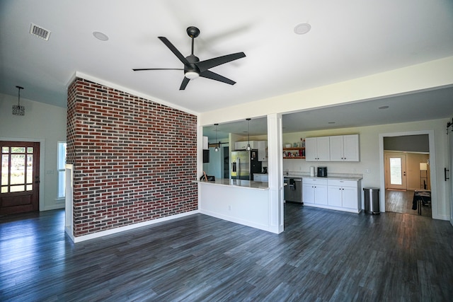 unfurnished living room with brick wall, vaulted ceiling, dark wood-type flooring, and ceiling fan