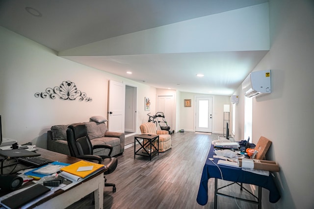 office space featuring hardwood / wood-style floors, a wall unit AC, and vaulted ceiling