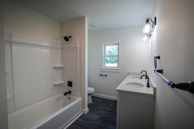 full bathroom featuring hardwood / wood-style floors, vanity,  shower combination, and toilet