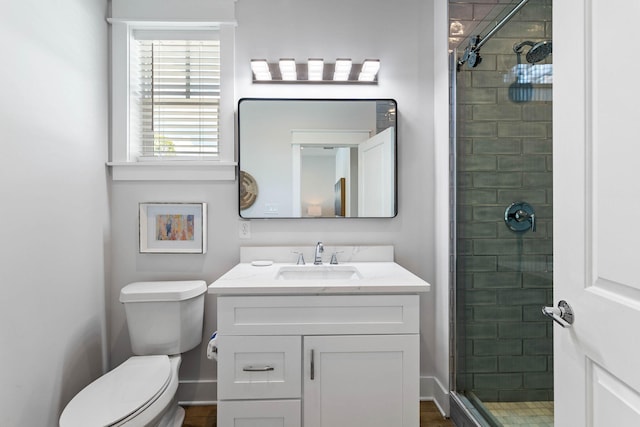 bathroom with vanity, toilet, and a shower with door