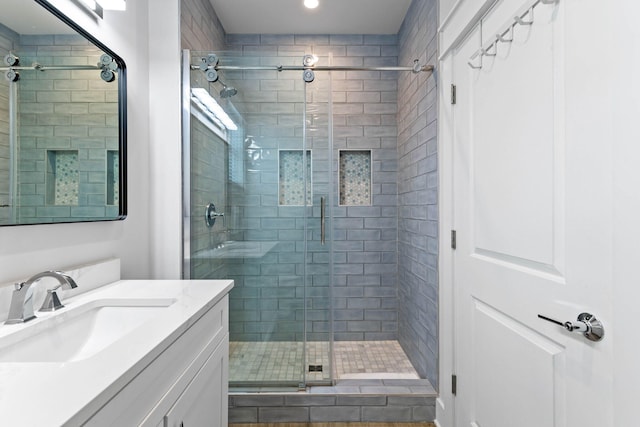 bathroom featuring walk in shower and vanity