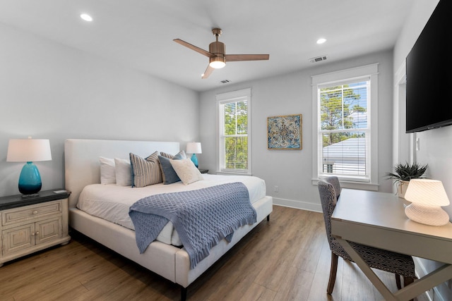 bedroom with ceiling fan, multiple windows, and dark wood-type flooring