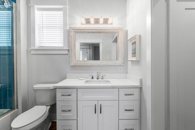 full bathroom featuring bath / shower combo with glass door, vanity, and toilet