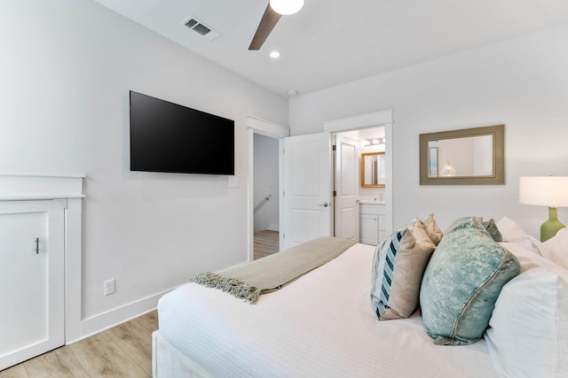 bedroom featuring ceiling fan, light hardwood / wood-style flooring, and ensuite bathroom