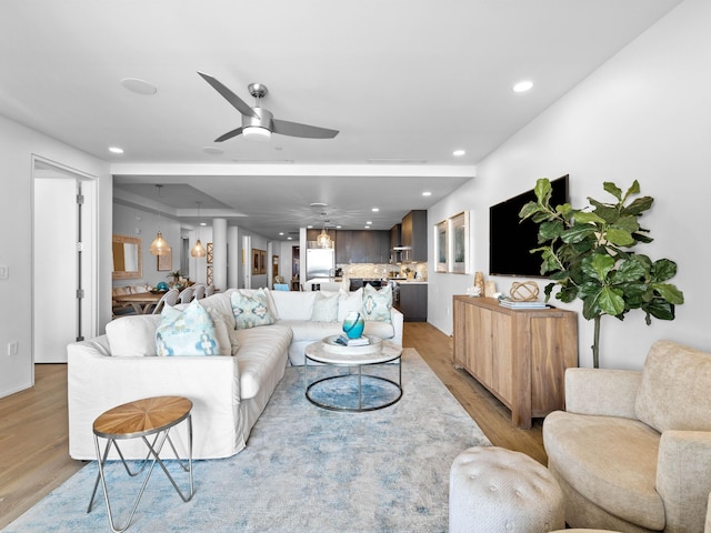 living room with ceiling fan and light wood-type flooring