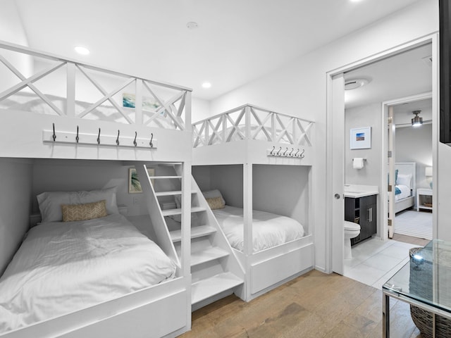 bedroom with connected bathroom and wood-type flooring