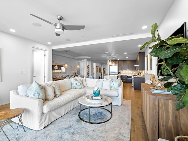 living room with light wood-type flooring and ceiling fan