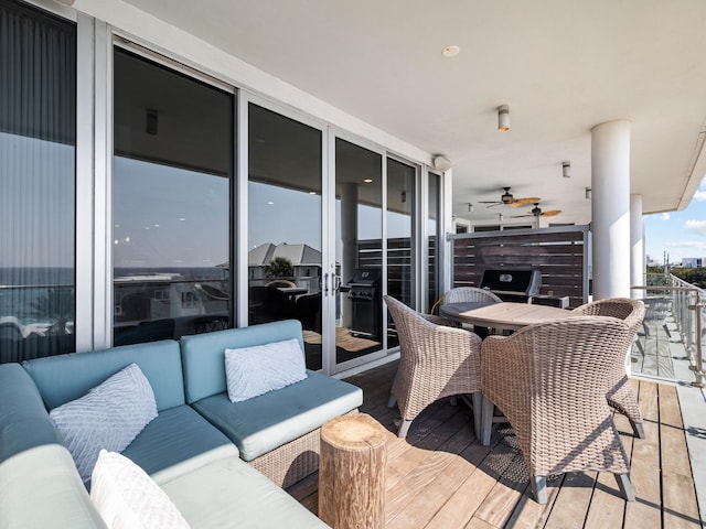 wooden terrace featuring outdoor lounge area, ceiling fan, and grilling area