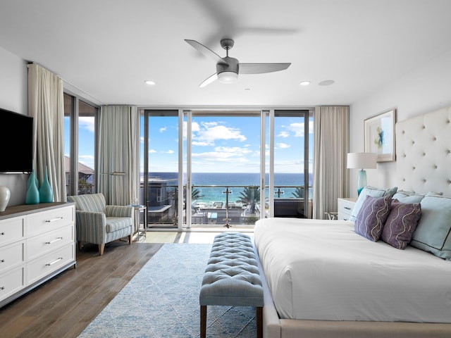 bedroom featuring a water view, access to exterior, multiple windows, and floor to ceiling windows