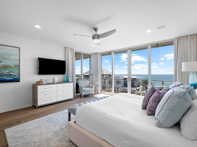 bedroom featuring dark hardwood / wood-style flooring, a wall of windows, access to outside, and ceiling fan