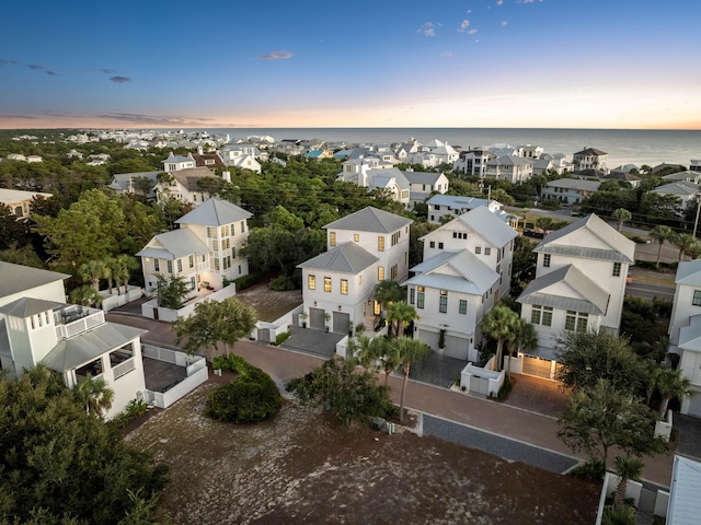 aerial view at dusk featuring a water view