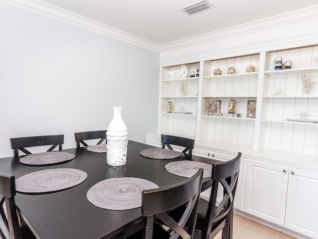 tiled dining space featuring crown molding