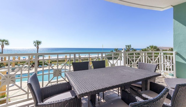 balcony featuring a view of the beach and a water view