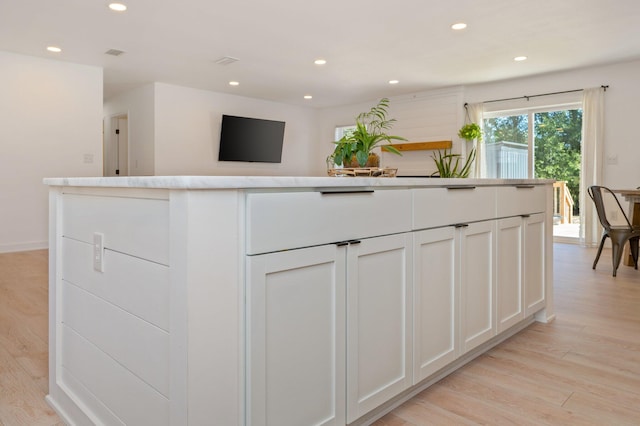 kitchen with white cabinetry and light hardwood / wood-style floors