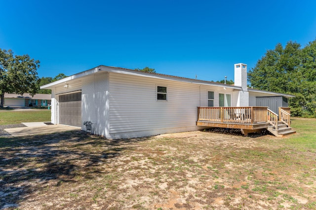 back of property featuring a deck and a lawn