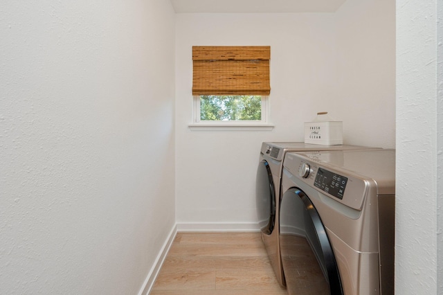 laundry area with light hardwood / wood-style flooring and separate washer and dryer