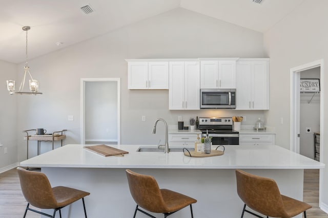 kitchen featuring white cabinets, a center island with sink, appliances with stainless steel finishes, and sink