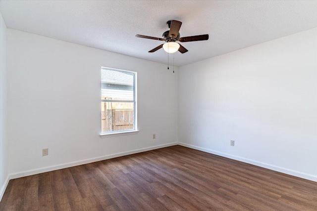 empty room with ceiling fan, dark hardwood / wood-style floors, and a textured ceiling