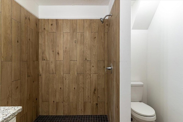 bathroom featuring a textured ceiling, a shower, vanity, and toilet