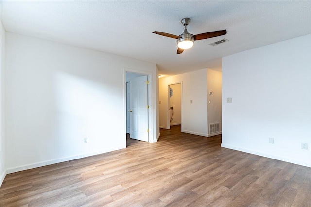 spare room featuring light hardwood / wood-style flooring, a textured ceiling, and ceiling fan