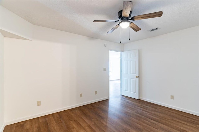 empty room featuring dark wood-type flooring, a textured ceiling, and ceiling fan