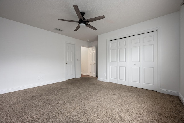 unfurnished bedroom with a closet, ceiling fan, carpet flooring, and a textured ceiling