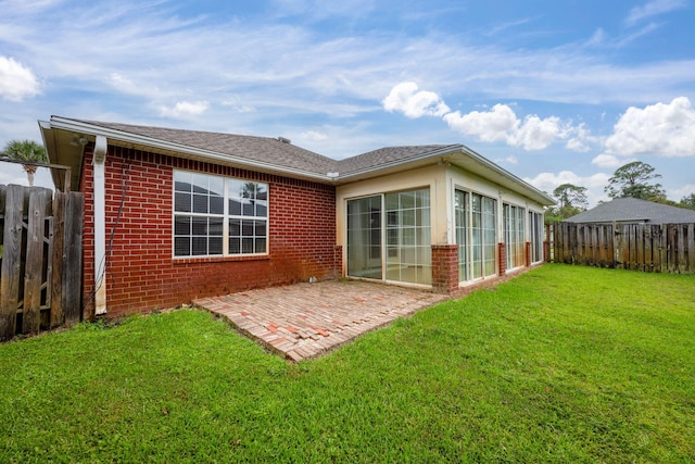 back of house with a patio and a yard