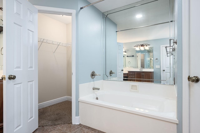 bathroom featuring a bathing tub, tile patterned flooring, and vanity