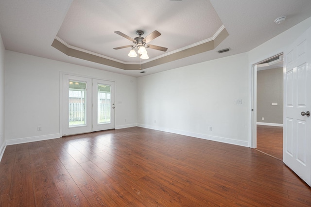 unfurnished room with a raised ceiling, ornamental molding, dark hardwood / wood-style flooring, and ceiling fan