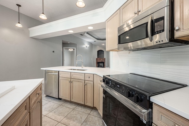 kitchen featuring appliances with stainless steel finishes, light tile patterned flooring, pendant lighting, ornamental molding, and sink