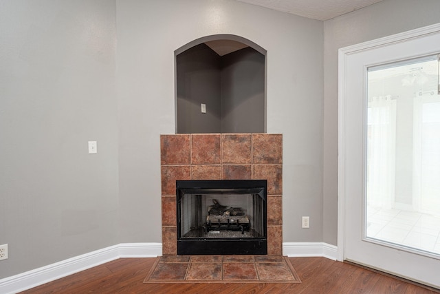 room details with a tiled fireplace and hardwood / wood-style floors