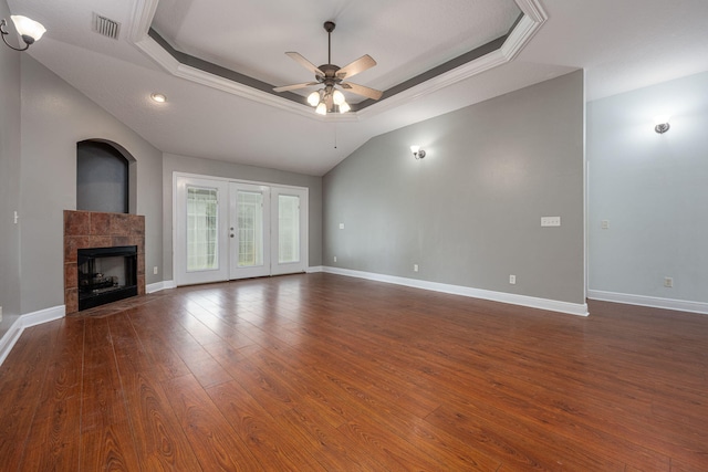 unfurnished living room with ceiling fan, a raised ceiling, and dark hardwood / wood-style floors