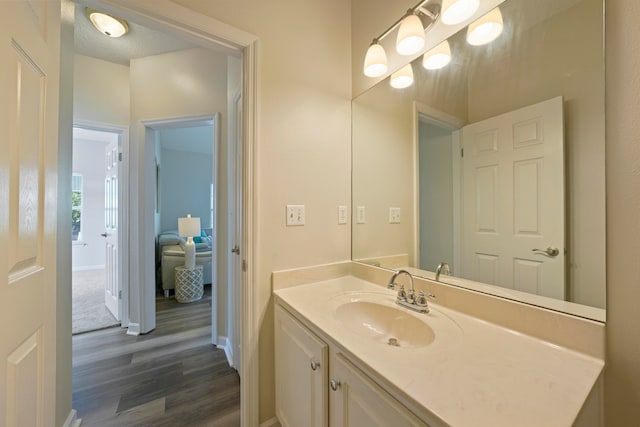 bathroom with hardwood / wood-style floors, vanity, and a textured ceiling