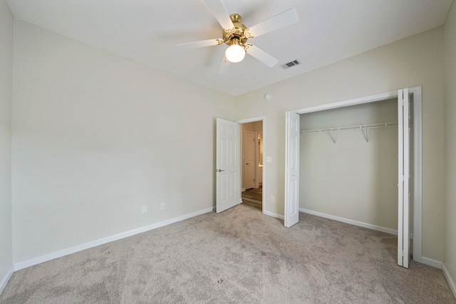 unfurnished bedroom featuring ceiling fan, a closet, and light colored carpet