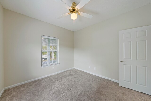 empty room featuring ceiling fan and light colored carpet