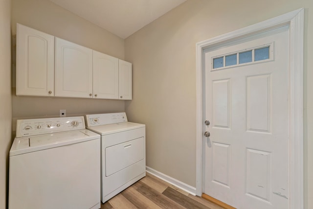 clothes washing area with cabinets, separate washer and dryer, and light hardwood / wood-style flooring