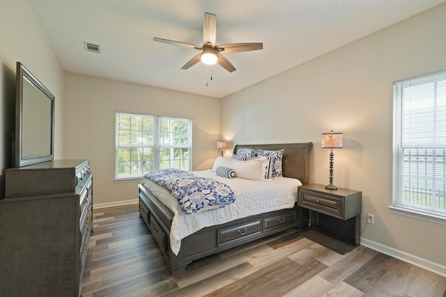 bedroom featuring hardwood / wood-style flooring, a textured ceiling, and ceiling fan