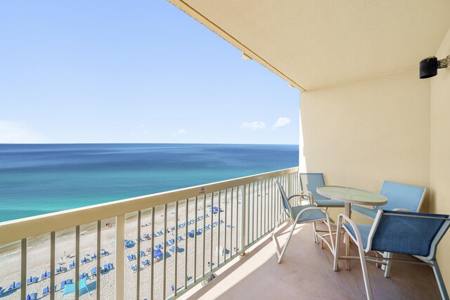 balcony featuring a view of the beach and a water view