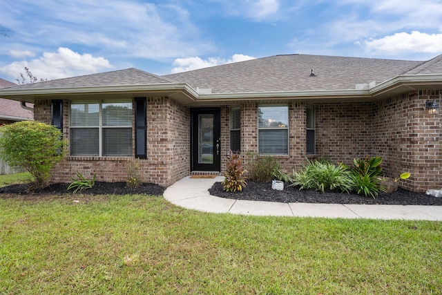 2826 Shoni Dr, Navarre, FL 32566 - view of exterior entry with a lawn, roof with shingles, and brick siding