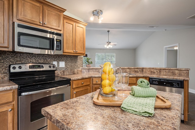 kitchen with ceiling fan, sink, stainless steel appliances, backsplash, and vaulted ceiling