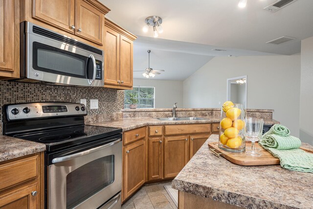 2826 Shoni Dr, Navarre, FL 32566 - kitchen featuring visible vents, appliances with stainless steel finishes, tasteful backsplash, a sink, and lofted ceiling
