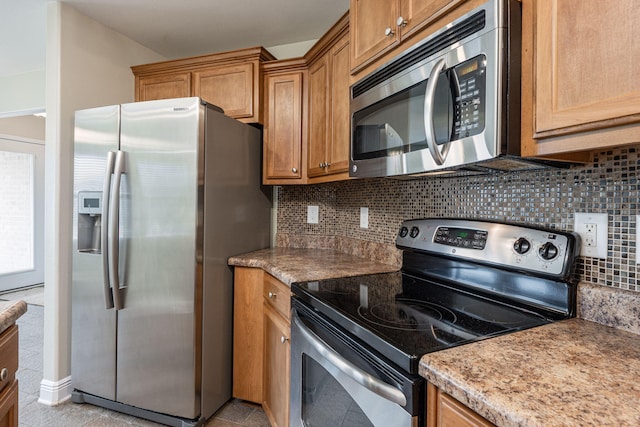 kitchen with appliances with stainless steel finishes, tasteful backsplash, and light tile patterned flooring