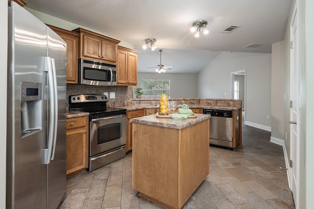 kitchen with a center island, stainless steel appliances, ceiling fan, and backsplash