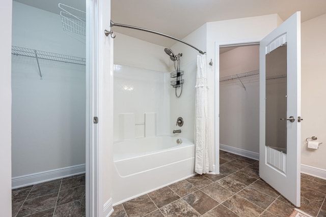 2826 Shoni Dr, Navarre, FL 32566 - bathroom featuring baseboards, shower / bath combination with curtain, a spacious closet, and stone finish floor