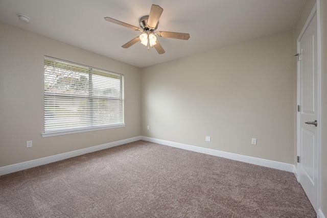 carpeted spare room featuring ceiling fan