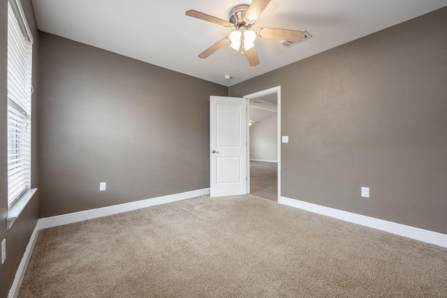 carpeted spare room featuring ceiling fan