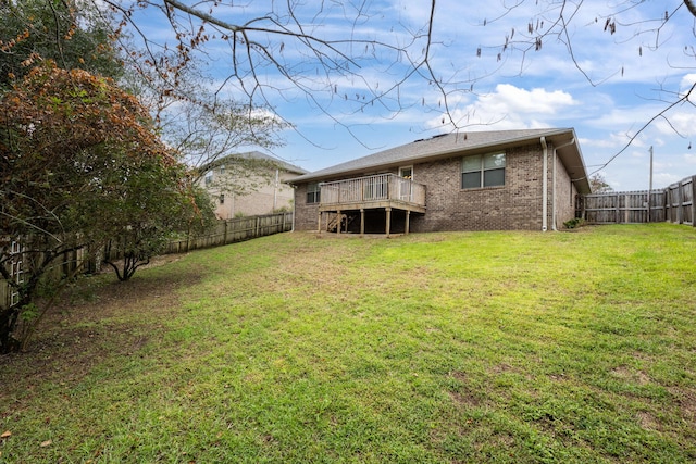 back of property featuring a lawn and a wooden deck