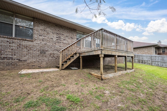 rear view of property with a wooden deck and a yard